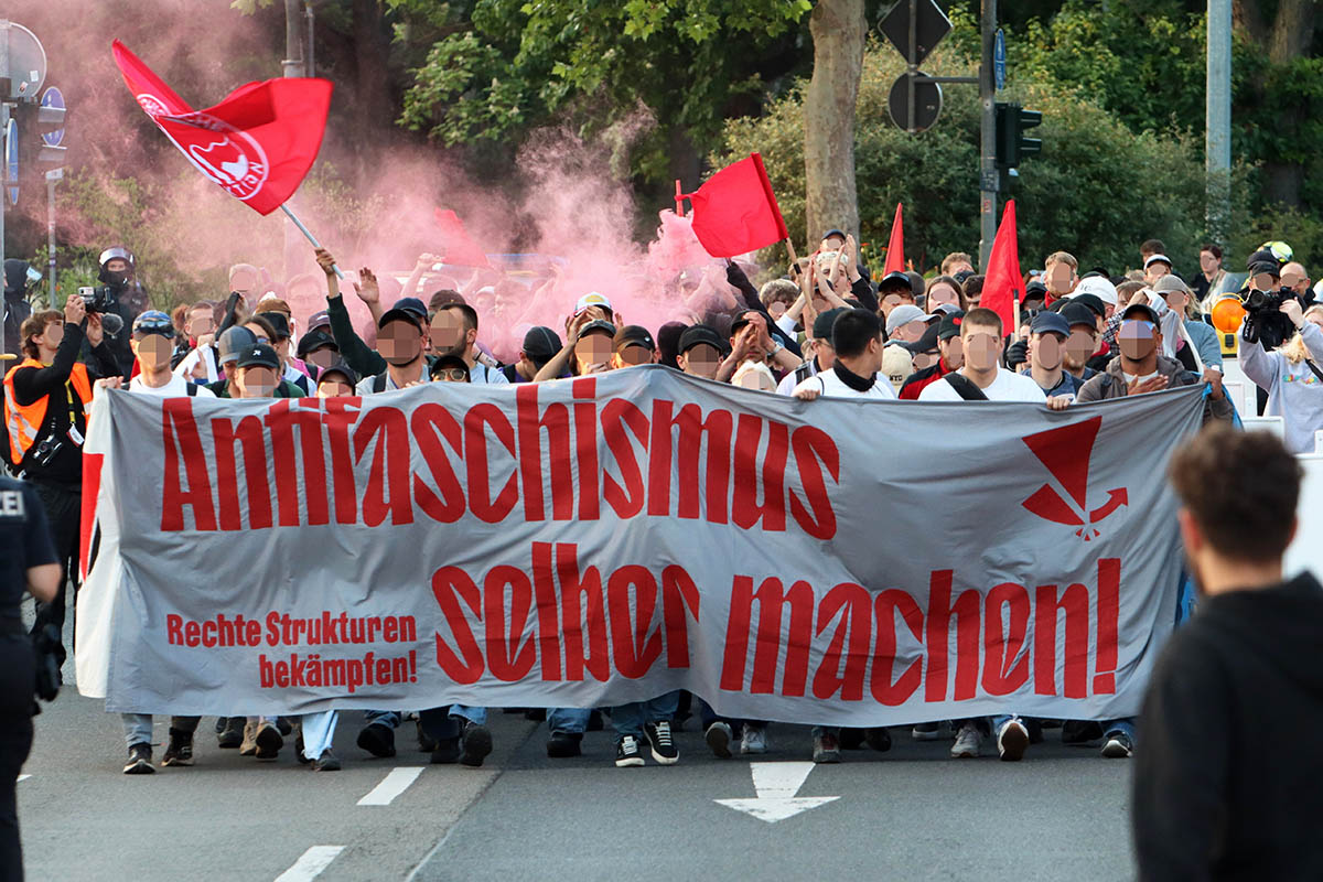 Foto: © Kinkalitzken via Umbruch Bildarchiv Das Foto von: © Kinkalitzken zeigt einen Block der Demo mit Seiten und Fronttransparenten. Der Text "Antifaschsimus selber machen - rechte Strukturen bekämpfen" dahinter mehrere Dutzend Demnstrant*innen, die zum Teil mit roten Fahnen dahinter laufen.